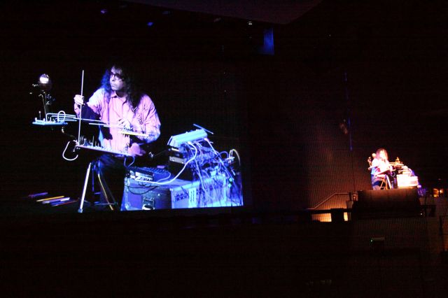 Projection of Applebaum performing with view of the composer/performer stage right as well.